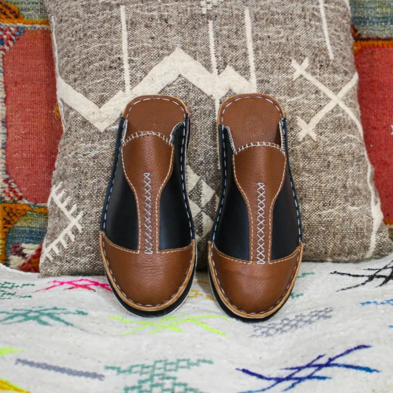 Babouches traditionnelles bicolores marron et noir sur tapis artisanal – artisanat marocain