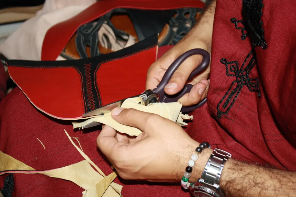 Artisan marocain en train de travailler le cuir à la main – artisanat marocain en cuir