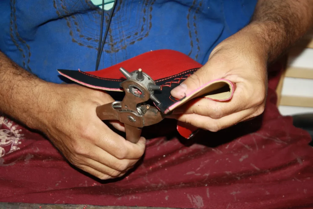 artisan marocain fabriquant une babouche femme marocaine en cuir